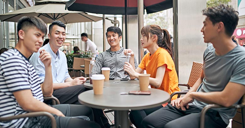 Young people drinking coffee at an outdoor coffee shop